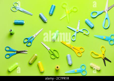 Scissors with sewing threads on color background Stock Photo