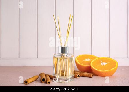 Reed diffuser, orange and cinnamon on table in room Stock Photo