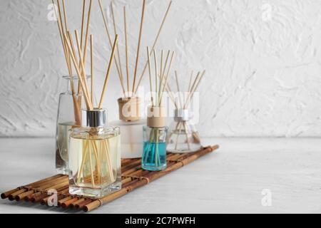 Different reed diffusers on table in room Stock Photo