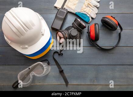Work safety protection equipment flat lay. Industrial protective gear on blue wooden background. Construction site health and safety concept, copy spa Stock Photo