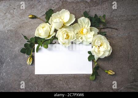 Blank stickers sheet in a flat lay setting for product mockups and social media posts. Featuring empty card surrounded by flowers Stock Photo