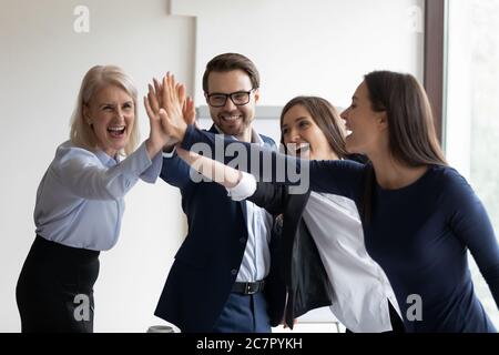 Happy multiethnic staff give high five celebrating achievement Stock ...