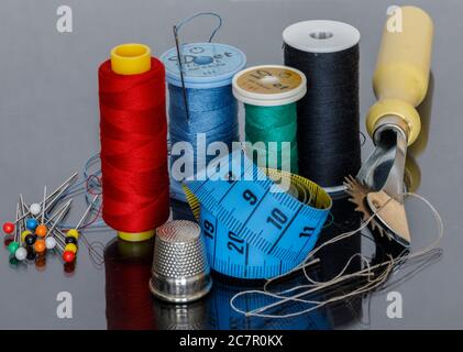 Various sewing items such as thread thimble tape measure and button pins Stock Photo