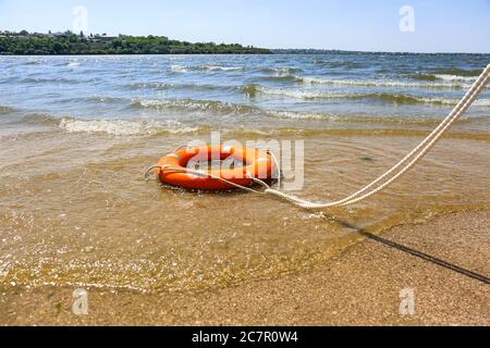 Bright lifebuoy ring on beach Stock Photo