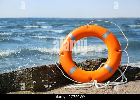 Bright lifebuoy ring on beach Stock Photo