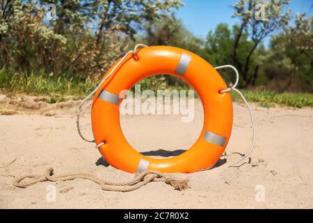 Bright lifebuoy ring on beach Stock Photo