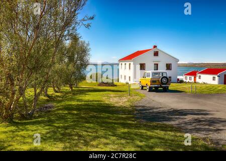 Beautiful landscape of sunny day at Lake Myvatn with green meadow and nice house near Reykjahlid town. Location: Reykjahlid town, Myvatn region, North Stock Photo