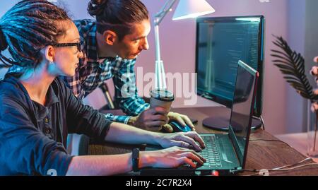 Programmers are developing software by working with software code together. Team work. Modern job of an IT engineer. Stock Photo