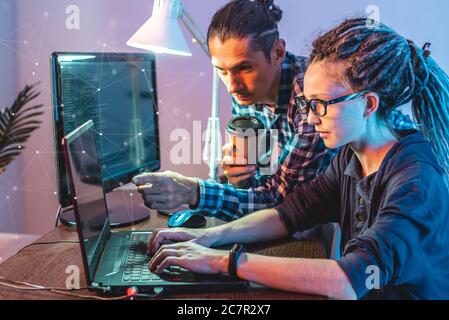 Programmers are developing software by working with software code together. Team work. Modern job of an IT engineer. Stock Photo