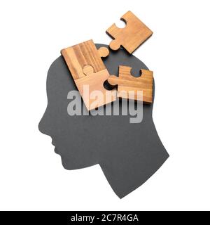 Paper human head and pieces of jigsaw puzzle on white background. Concept of dementia Stock Photo