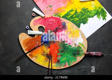 Vibrant multi-coloured artists oil or acrylic paints palette on textured  white paper with paintbrushes Stock Photo - Alamy