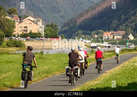 Group of people ride on cycle path leading along Elbe river Saxony Germany biking Stock Photo