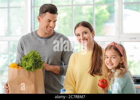 Family unpacking fresh products from market in kitchen Stock Photo