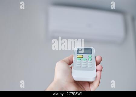 Remote control for air conditioner in hand. Room condition remote control. Air temperature switch for cooling of space. Stock Photo