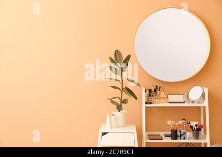 Rack with decorative cosmetics and mirror in modern makeup room Stock Photo