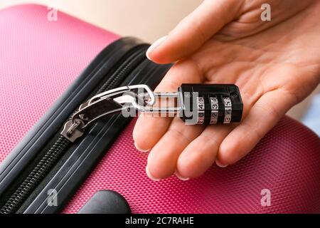 Woman with lock on suitcase, closeup Stock Photo