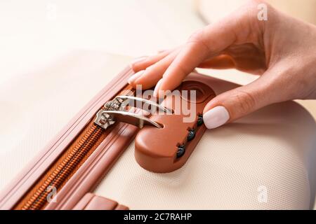 Woman opening lock on suitcase, closeup Stock Photo