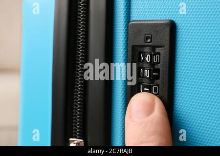 Man opening lock on suitcase, closeup Stock Photo