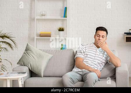 Young man suffering from sleep deprivation at home Stock Photo