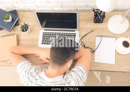Young man falling asleep during work in office. Concept of sleep deprivation Stock Photo