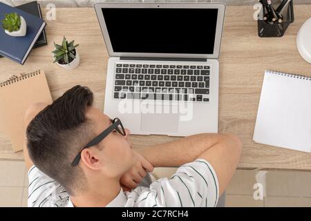 Young man falling asleep during work in office. Concept of sleep deprivation Stock Photo
