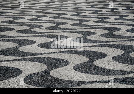 Typical portuguese cobblestone hand-made mosaic pavement, in Rossio Square or Pedro IV Square (Praça de D. Pedro IV), Lisbon, Portugal. Stock Photo