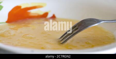 Closeup shot of a fork and beaten egg yolks for an omelet Stock Photo