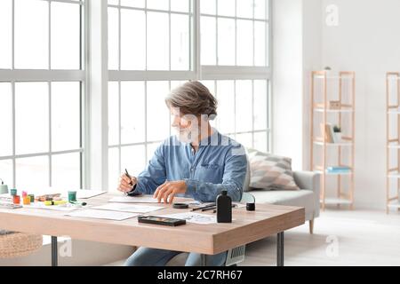 Senior male calligraphist working in office Stock Photo