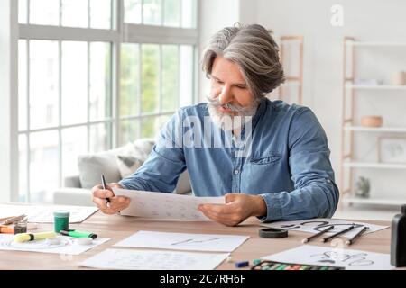 Senior male calligraphist working in office Stock Photo