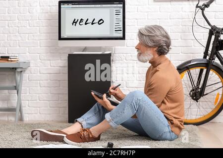 Senior male calligraphist working in office Stock Photo