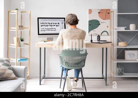 Senior male calligraphist working in office Stock Photo