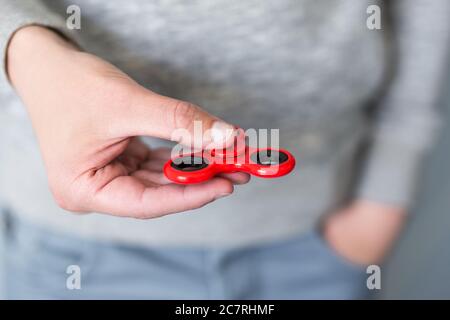 boy or young man playing with red fidget spinner Stock Photo