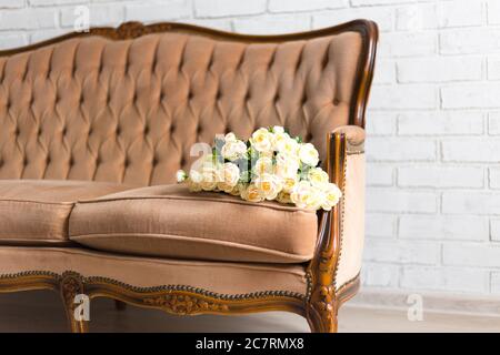 close up of beautiful rose flowers on vintage sofa Stock Photo