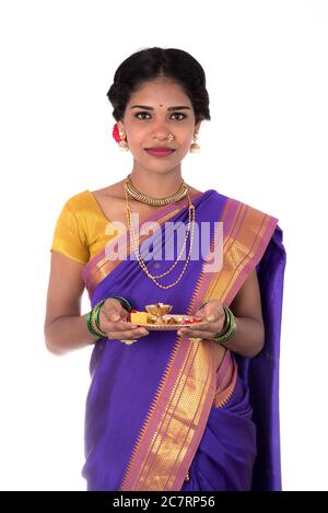 Indian woman performing worship, portrait of a beautiful young lady with pooja thali isolated on white background Stock Photo