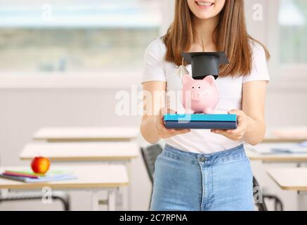 Teenage girl with savings for education in classroom Stock Photo