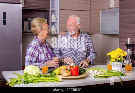 Beautiful elderly couple cooking in the kitchen with each other Stock Photo