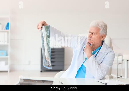 Senior neurologist with MRI scan of human head in clinic Stock Photo