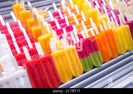 colorful assorted fruit popsicles on market stall Stock Photo