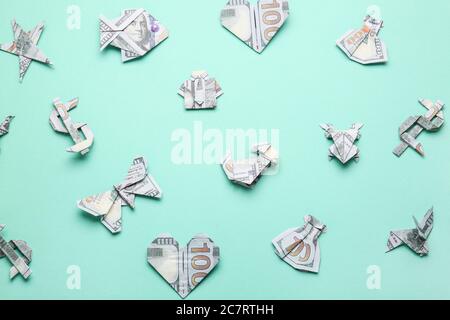 Origami figures made of dollar banknotes on color background Stock Photo
