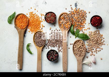 Spoons with lentils and spices on white background Stock Photo