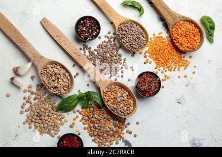 Spoons with lentils and spices on white background Stock Photo