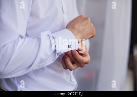 The man in the white shirt in the window dress cufflinks Stock Photo