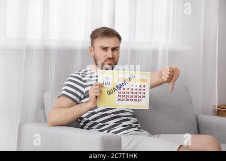 Displeased man with calendar dreaming about vacation during quarantine at home Stock Photo