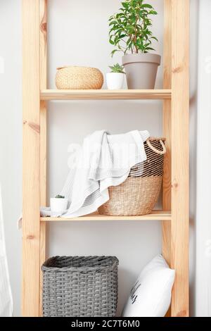 Rack with wicker baskets in room Stock Photo