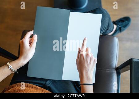 woman is holding and pointing on an empty page as template texture, card, menu or brochure . High quality photo Stock Photo