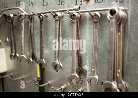 set of old wrenches and spanners on metal wall Stock Photo