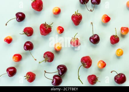 Colourful bright pattern with ripe cherry and strawberries. Top view.berry seamless pattern, strawberry and colorful cherries on pastel background Stock Photo