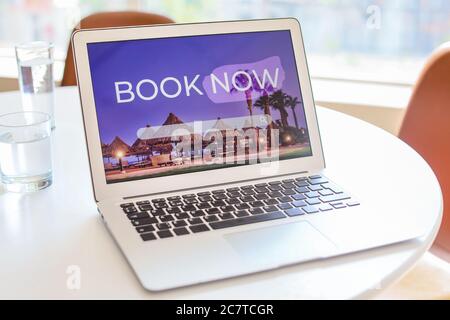 Open page of online booking service on screen of laptop on table Stock Photo