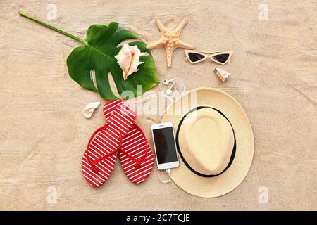 Beach accessories and mobile phone on sand background Stock Photo