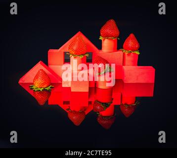 Strawberries on red geometrical structures on black background Stock Photo